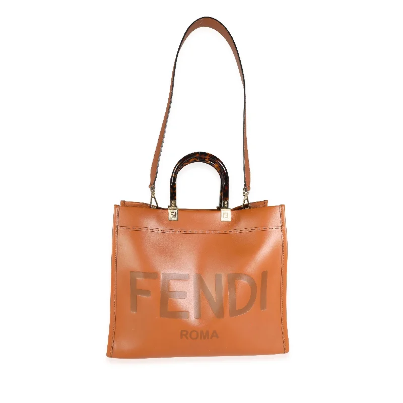 Fendi Baguette bags with a detachable charm featuring the brand's mascotFENDI Brown Debossed Leather & Tortoiseshell Plexiglass Medium Sunshine Shopper